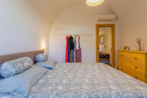 焦维纳佐IL Marinaretto的一间卧室配有一张带蓝色枕头的床和梳妆台