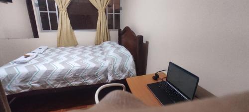 拉塔昆加Estefanyyyy的一间卧室配有一张床和一张桌子上的笔记本电脑