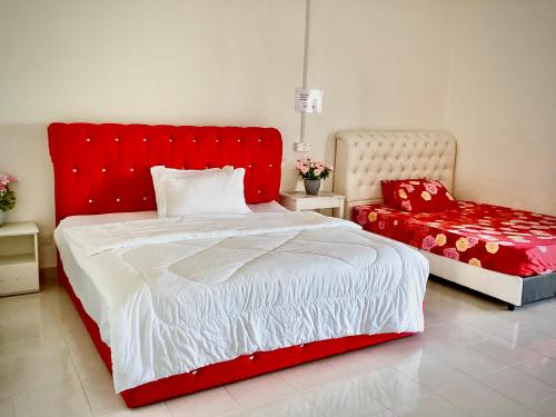 金宝Homestay Kampar Putra的一间卧室配有红色的床和红色椅子