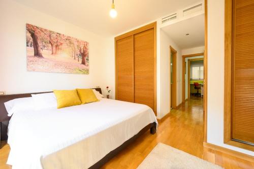 马拉加Apartamento Litoral Blue的卧室配有一张带黄色枕头的大型白色床。