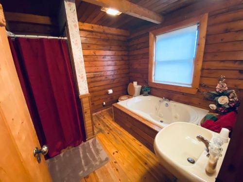 尤里卡斯普林斯Cozy Cabin at Bear Mountain Log Cabins的带浴缸和盥洗盆的浴室