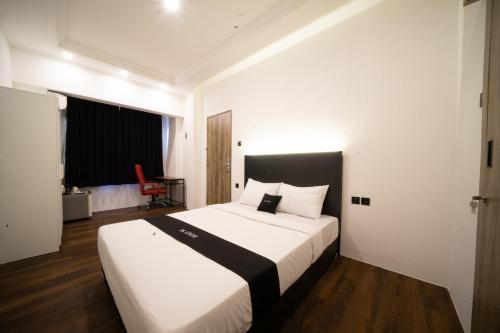 CandiDS Colive Sinabung的一间卧室配有一张白色大床和黑色床头板