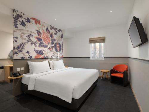 棉兰瑞士-贝林美丹酒店的卧室配有白色的床和红色椅子
