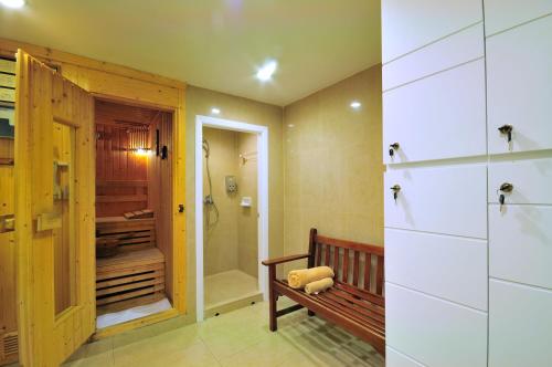 曼谷水门中心点酒店的一间带长凳和步入式淋浴间的浴室