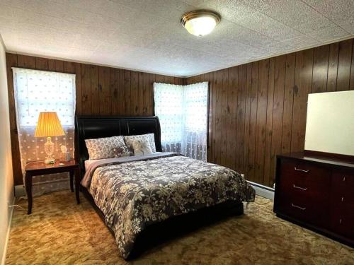 布法罗Entire Home in Buffalo - 6 Guests 3 Bedroom 1 Bath - Convenient Location 7 mins from Airport的一间卧室配有一张床、一张桌子和一盏灯