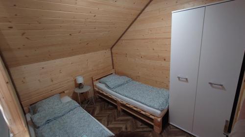 奥克宁卡SOSNOWY ZAKĄTEK的小屋内带两张床的小房间