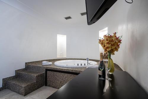 诺维萨德GARNI HOTEL AMI的浴室设有水槽和花瓶