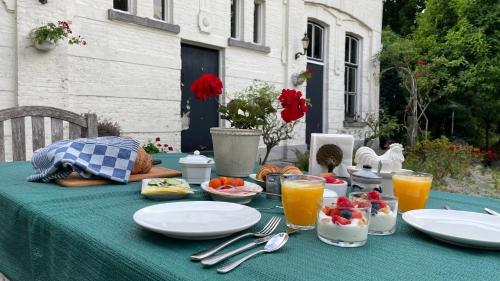 OudenboschBed & Breakfast By Genck的一张桌子,上面有盘子,放在绿色的桌布上