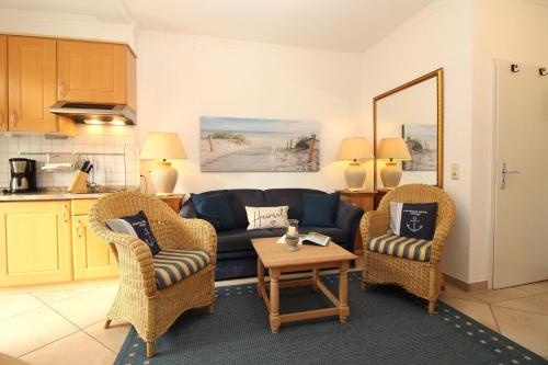 奥斯赛拜-屈隆斯博恩Haus Kühlung Fewo 3的客厅配有蓝色的沙发和两把椅子