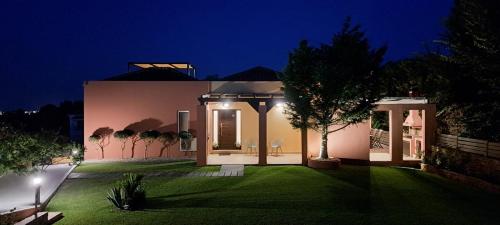 古维亚Villa Magic Perla的绿色草坪的夜晚房屋