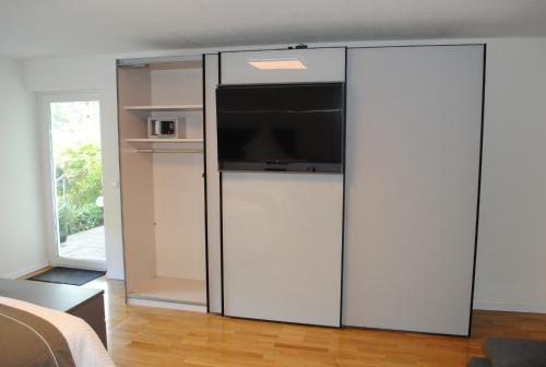 巴登韦勒FeWo-Hochblauen的大型白色冰箱,上面配有电视