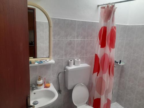 里瓦的亚Seva' s Studios的浴室设有红色和白色的浴帘和卫生间