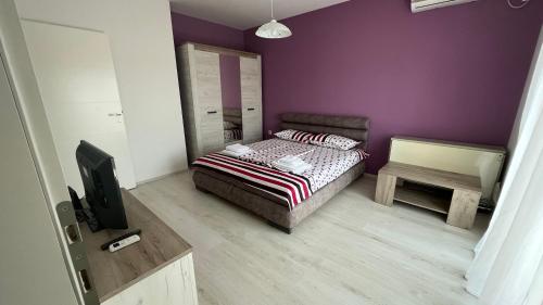 帕拉钦Harmony Relax的一间卧室配有一张床和紫色的墙壁