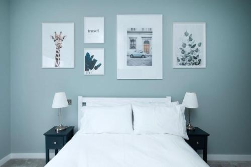伦敦Oak Tree Lodge的卧室配有一张白色床,墙上挂有照片