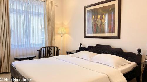 顺化顺化尼诺酒店的卧室设有一张白色大床和一扇窗户。
