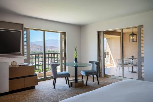 印第安维尔斯Renaissance Esmeralda Resort & Spa, Indian Wells的一间卧室配有一张床和一张桌子及椅子