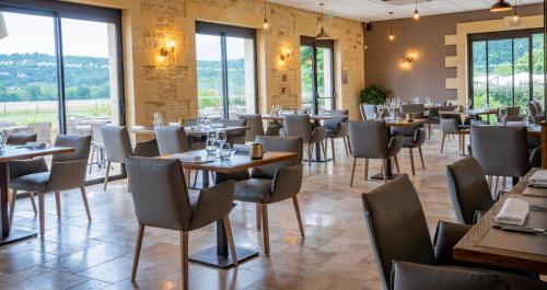 拉罗克加雅克佩里戈尔酒店的餐厅设有桌椅和窗户。
