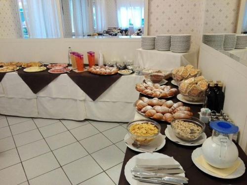 里米尼Hotel Villa Mon Reve的一张桌子上放着许多盘子的食物