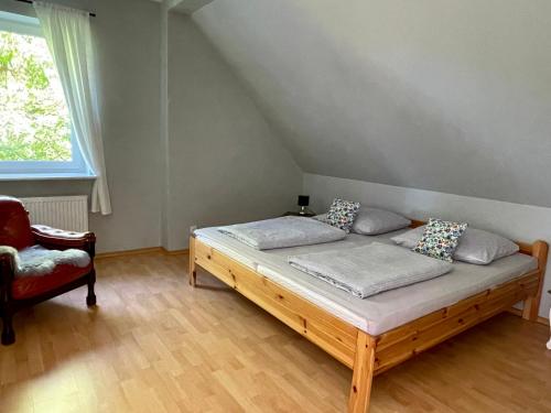 DębogardSielski wypoczynek blisko Kołobrzegu的一间卧室配有一张木床和一把椅子
