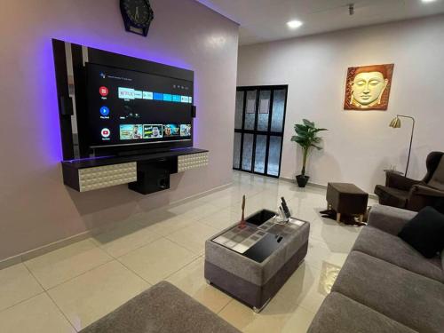 甘文丁Cozy Stay At Raintown Taiping的客厅配有大屏幕平面电视