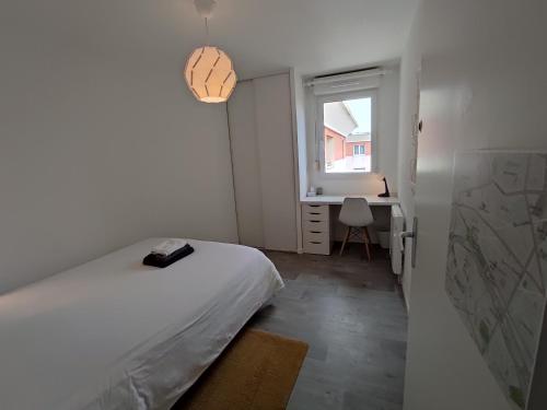 勒阿弗尔Appartement Terrasse Sud Dernier étage + Parking的一间卧室配有一张床、一个窗口和一张书桌