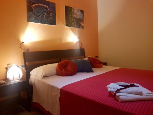 米拉佐Driade H的一间卧室配有一张带红色枕头的床