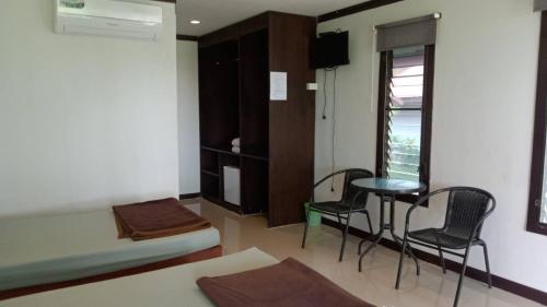 恰洛克拉姆Phangan Chalet Bungalow & House的配有一张床和一张桌子及椅子的房间