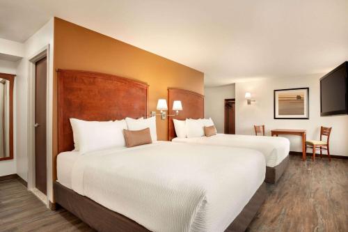 舍伍德帕克舍伍德帕克戴斯酒店的酒店客房设有两张床和一张桌子。