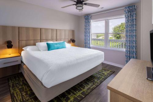 大西洋滩Atlantic Beach Resort, a Ramada by Wyndham的一间卧室设有一张大床和一个窗户。