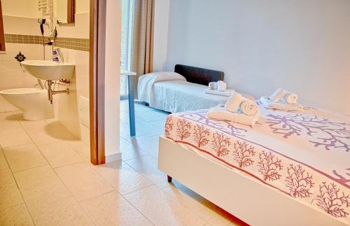 Uri考拉鲁坎达撒森图酒店的一间卧室配有一张床,浴室设有水槽