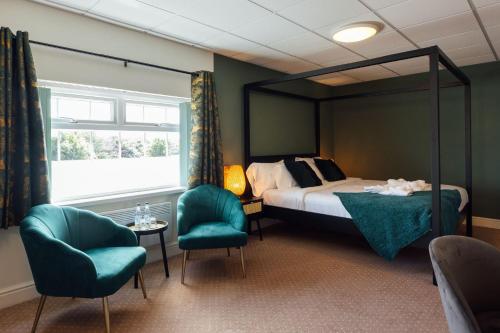 桑德斯富特The Imperial Dragon Hotel的一间卧室配有一张床和两把椅子
