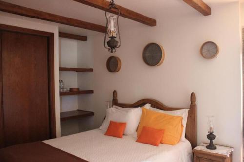 Mendiga丽池利迪娅酒店 - 图力士姆的一间卧室配有带橙色枕头的床