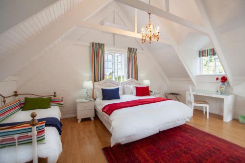 德班维尔柯西米酒店的白色阁楼卧室配有2张床和吊灯