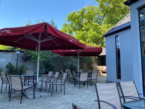 科布列季Level Up Hotel & Restaurant的一个带桌椅和遮阳伞的庭院
