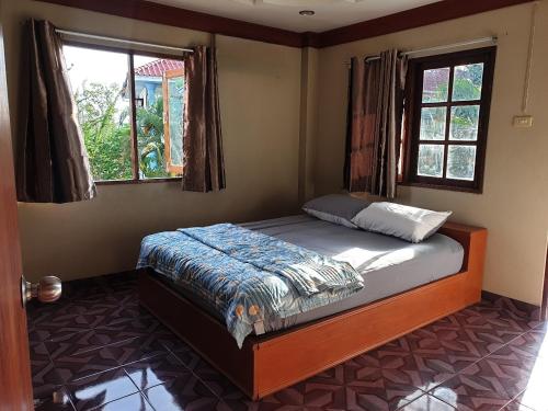 涛岛Tommy Resort Koh Tao的卧室配有床,位于带2个窗户的房间