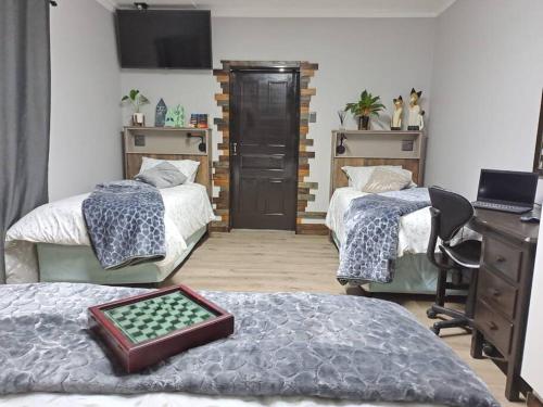布隆方丹Mossie Nes - Self Catering的一间卧室配有两张床、一张桌子和一张书桌