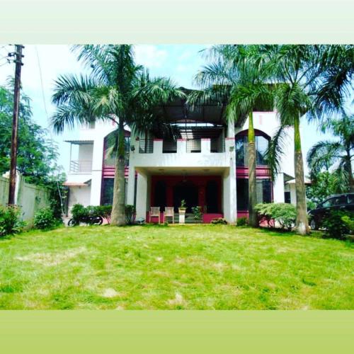 卡尔贾特KARJAT HOUSE的庭院前有棕榈树的房子