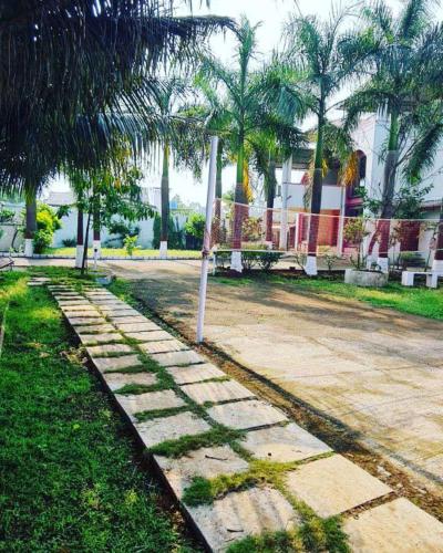 卡尔贾特KARJAT HOUSE的公园内种有棕榈树的石头人行道
