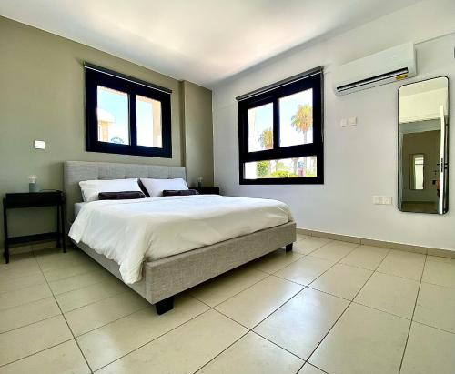 帕福斯Sea La Vie #2 - Luxury Seaview apartment的一间卧室设有一张大床和两个窗户。