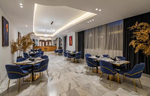 利雅德Hadab Al Sahafa的一间配备有桌子和蓝色椅子的用餐室