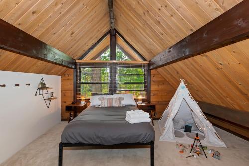大熊湖New!!! Dreamy Bear Haus- Updated Retro Retreat & Spa, Pet & Kid Friendly的一间带一张床的卧室,位于带木制天花板的房间内