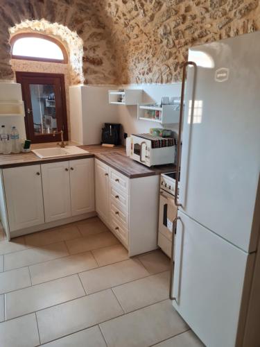 希俄斯Village home的厨房配有白色橱柜和冰箱。