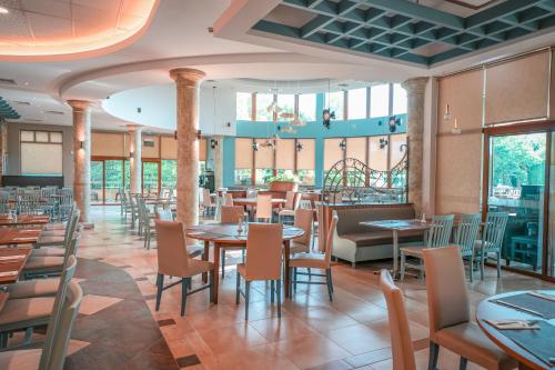 阿尔贝纳Calimera Ralitsa Superior Hotel - Ultra All Inclusive plus Aquapark的用餐室设有桌椅和窗户。
