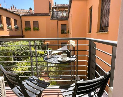 博洛尼亚Alfea Suite的阳台配有两把椅子和一张桌子