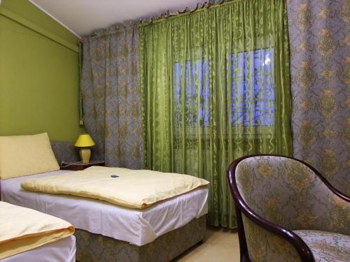 波热加Bed & Breakfast Vila Stanišić的一间卧室设有两张床,窗户设有绿色窗帘