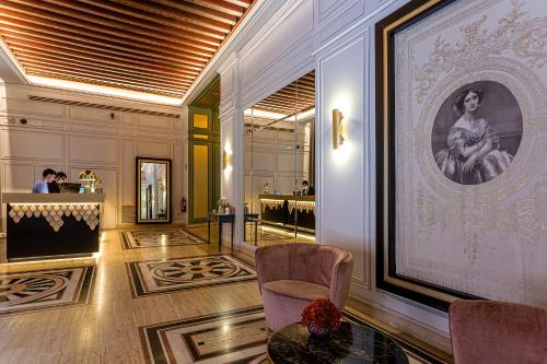 托莱多欧仁妮德蒙蒂若傲途格精选酒店的大厅里,有椅子和一张女人的照片