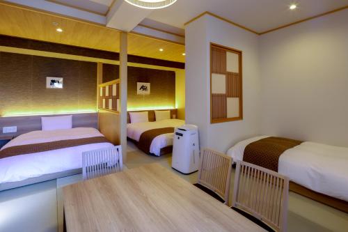 东京Dormy Inn Premium Ginza的一间设有两张床和一张桌子的房间