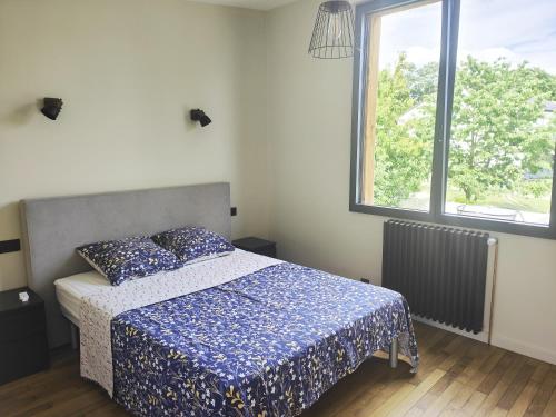 欧奈索斯博伊斯Sara的一间卧室配有一张带蓝色棉被的床和窗户。
