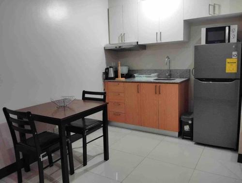 马尼拉Spacious 1 bedroom unit in Araneta Center Cubao的一间带桌子和冰箱的小厨房