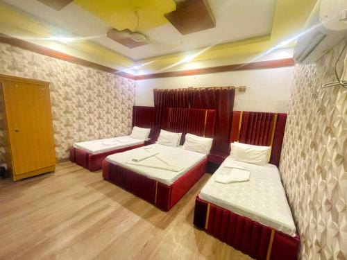 卡拉奇Rehaish Inn的一间客房内配有两张床的房间